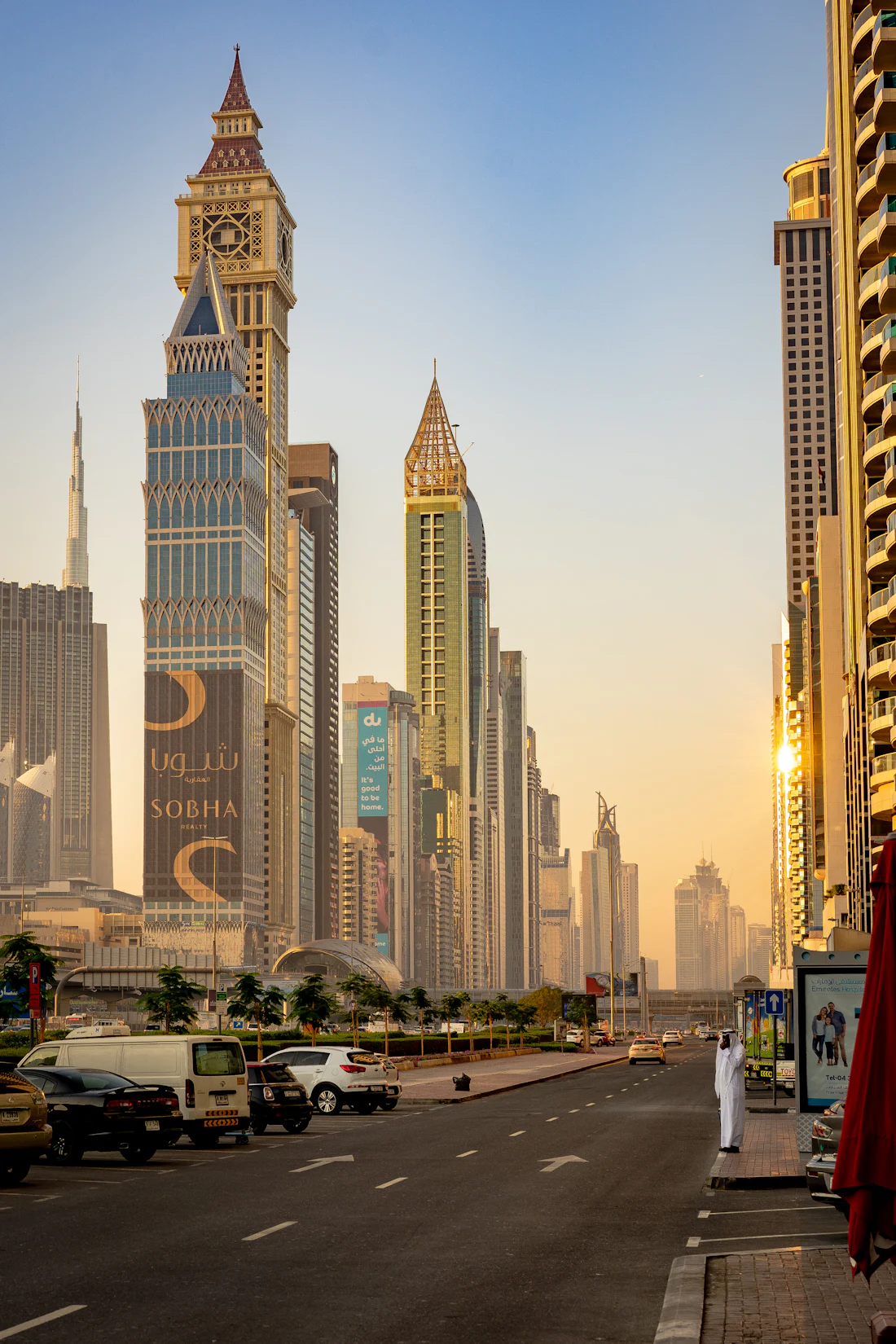 A man in traditional dress on a Dubai street at golden hour