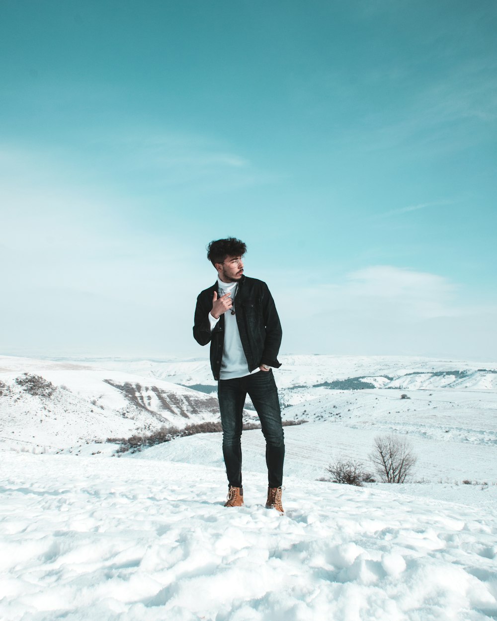man standing on snow-covered field during daytime