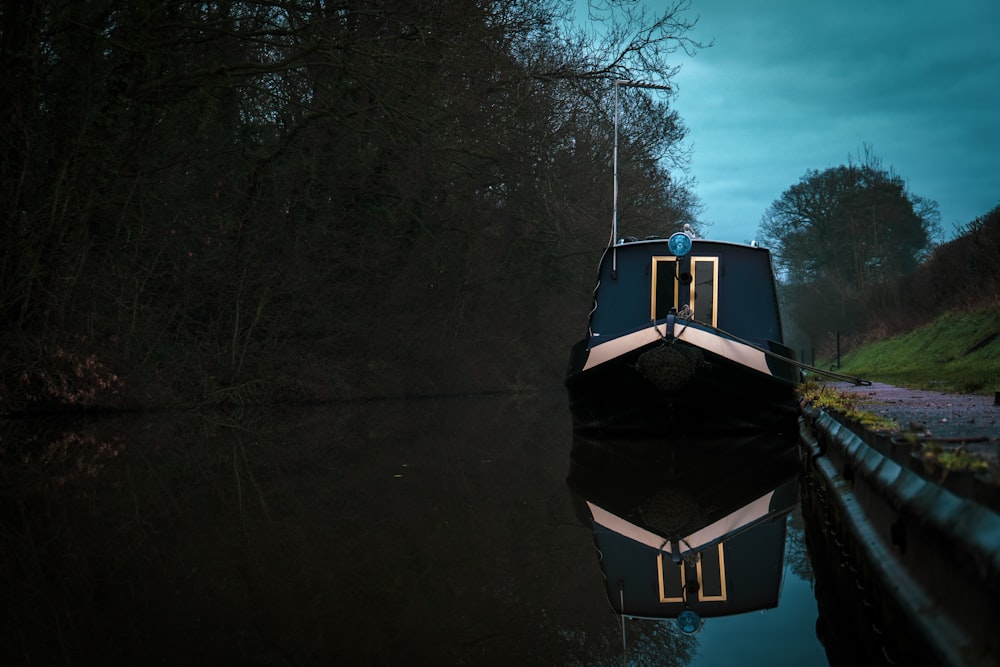 trees near boat beside concrete pavement