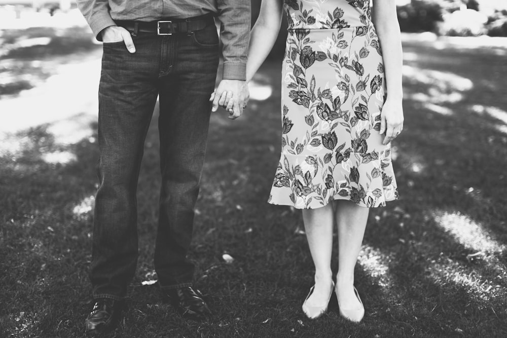 grayscale photography of man and woman holding hands
