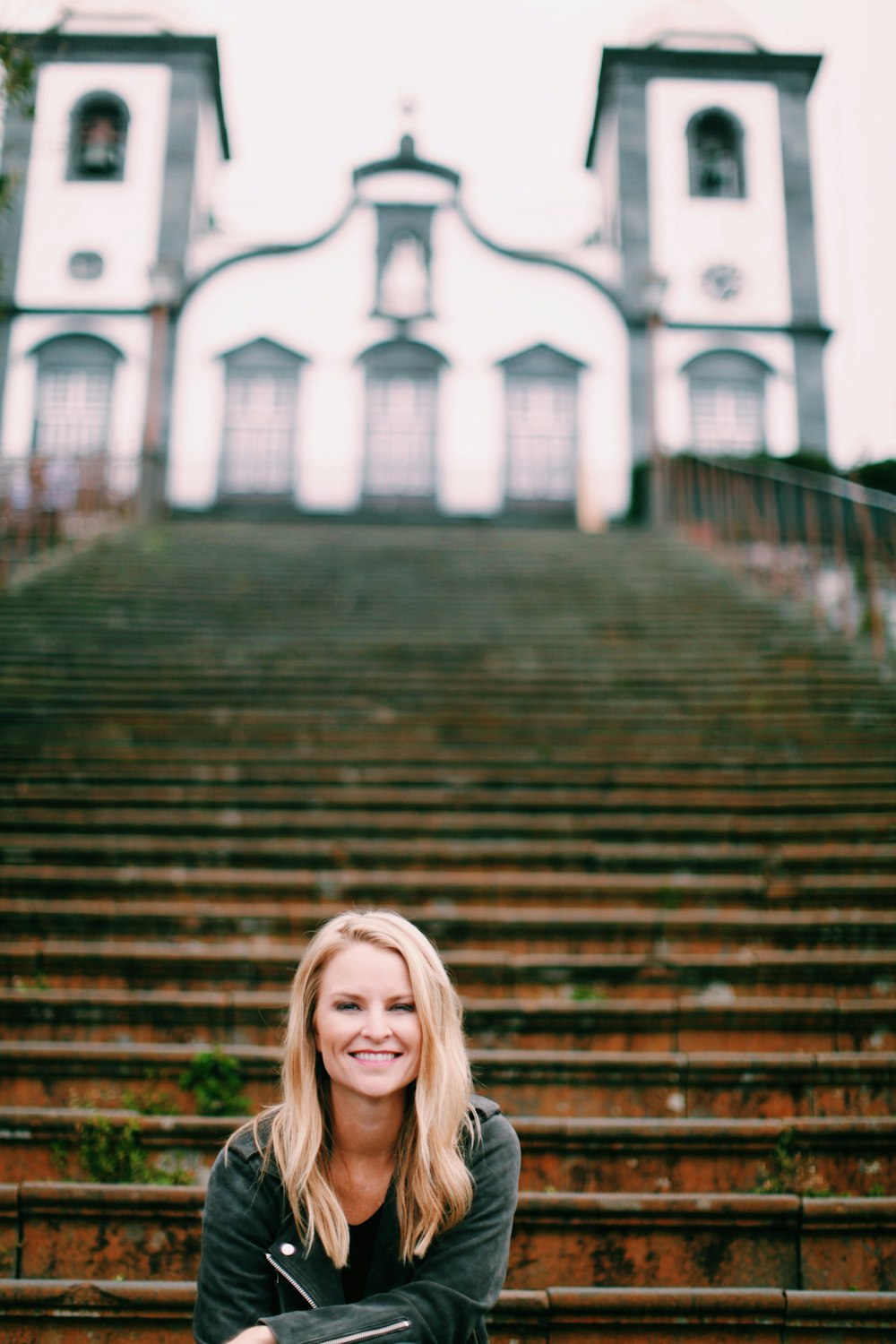 smiling woman sitting on stairway