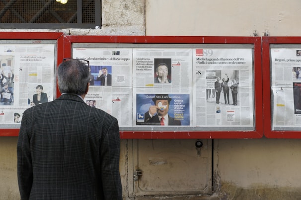 man reading newspaper in bulletin board