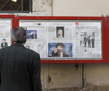 man reading newspaper in bulletin board