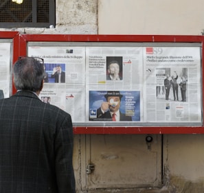 man reading newspaper in bulletin board