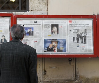 man reading newspaper in bulletin board