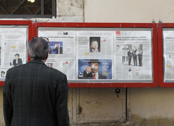 man reading newspaper in bulletin board