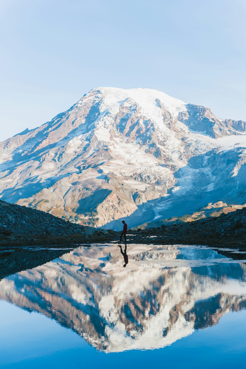 man walking near glacier mountain during day