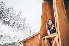 Carol smiling warmly while enjoying a morning coffee on her cozy balcony