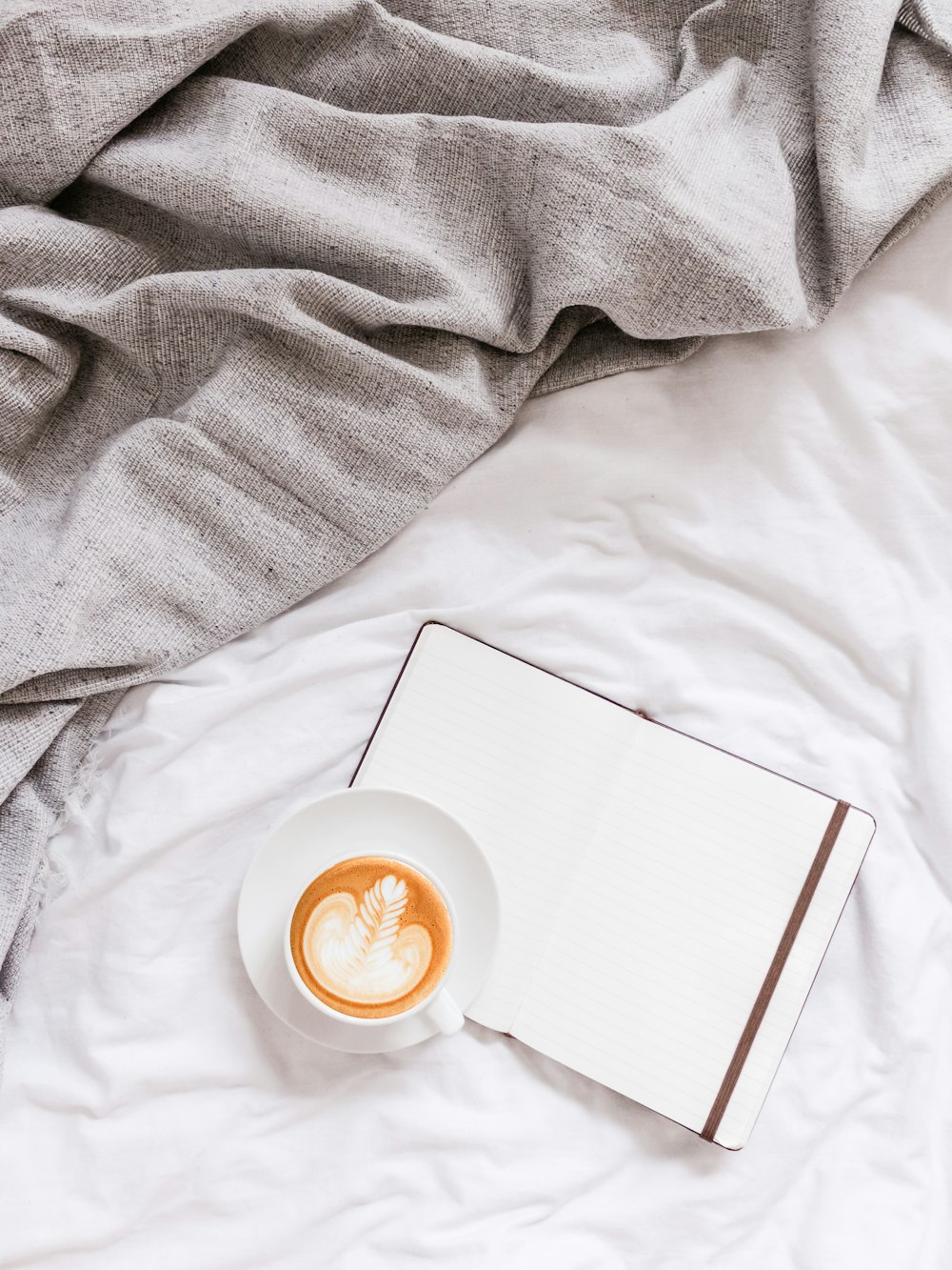 flat lay photography of white card under cup of cappuccino