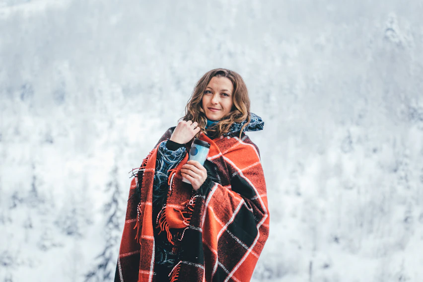 woman wearing red and black checked cape