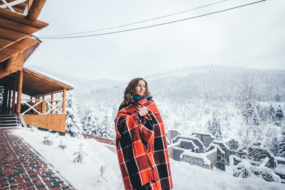 woman using red and black comforter