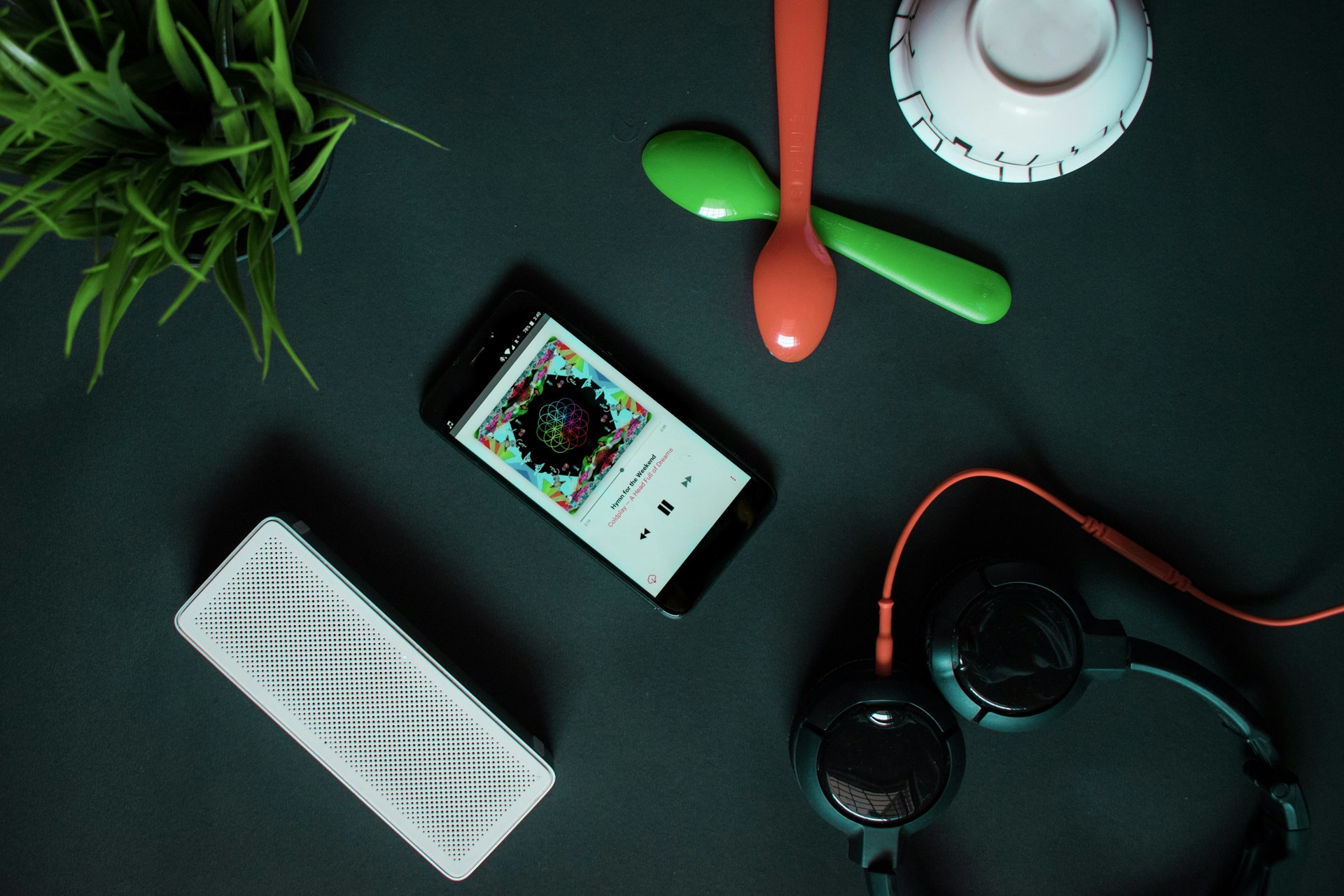 A stylish flat lay of headphones, vinyl records, and a smartphone displaying the noso media hub interface, blending classic and digital music culture.