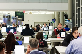 A traveler using a tablet to learn English phrases while sitting at an airport lounge.