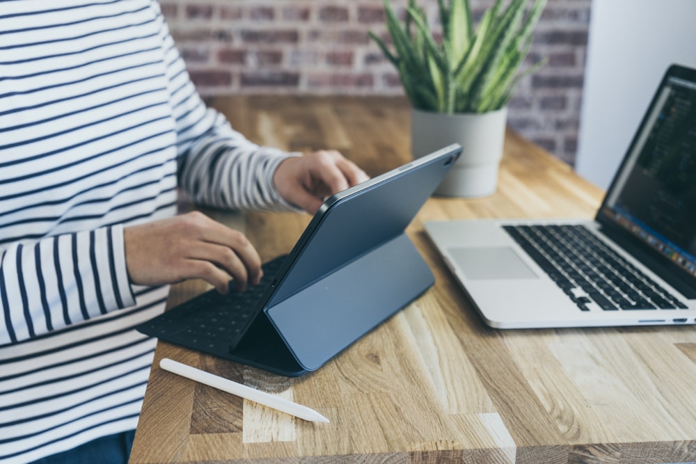 person sitting beside tablet computer with keyboard