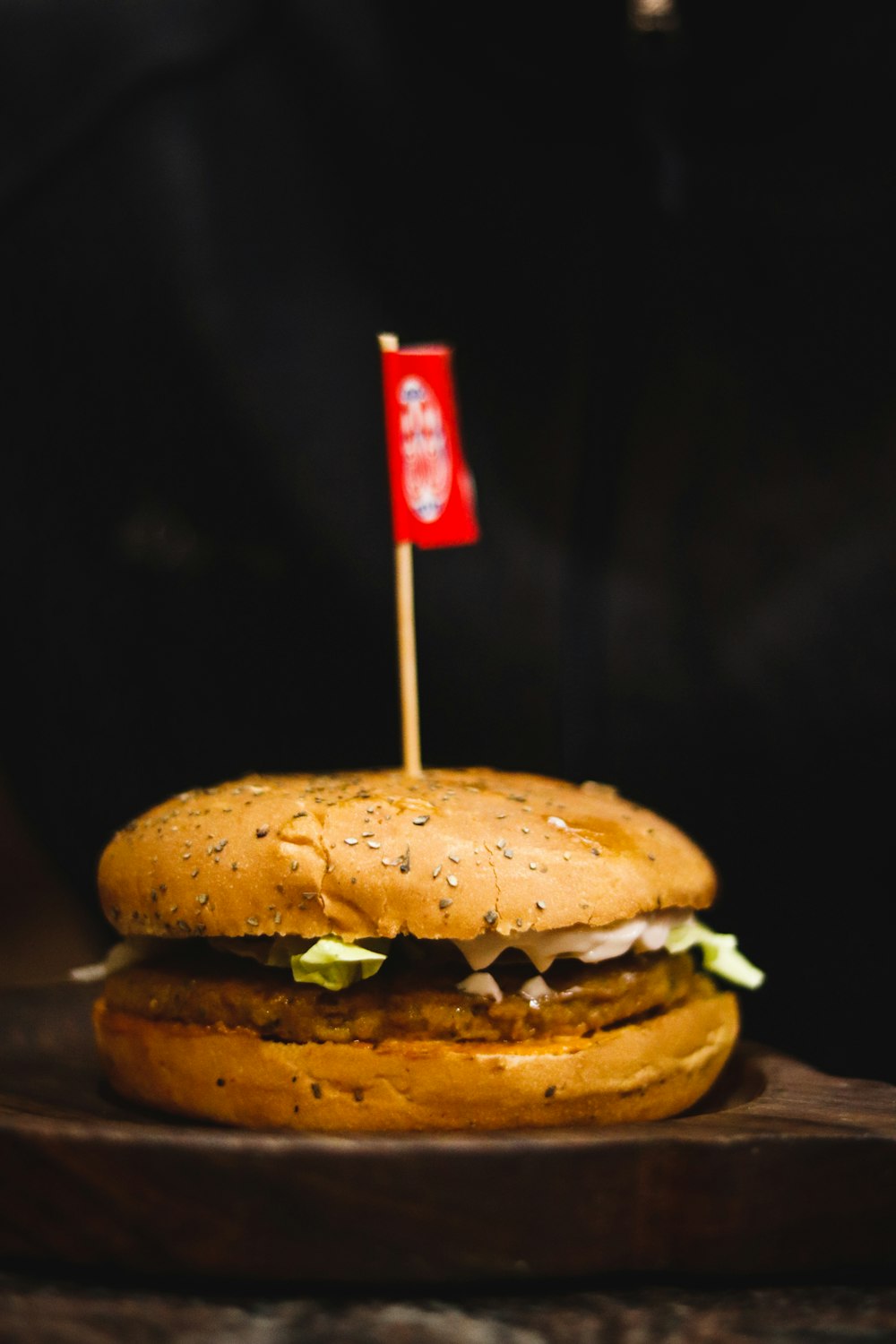 hamburger on wooden surface with small flag