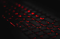 Close-up of a high-end keyboard with red backlighting on a minimalist white background.