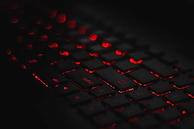Close-up of a high-end keyboard with red backlighting on a minimalist white background.