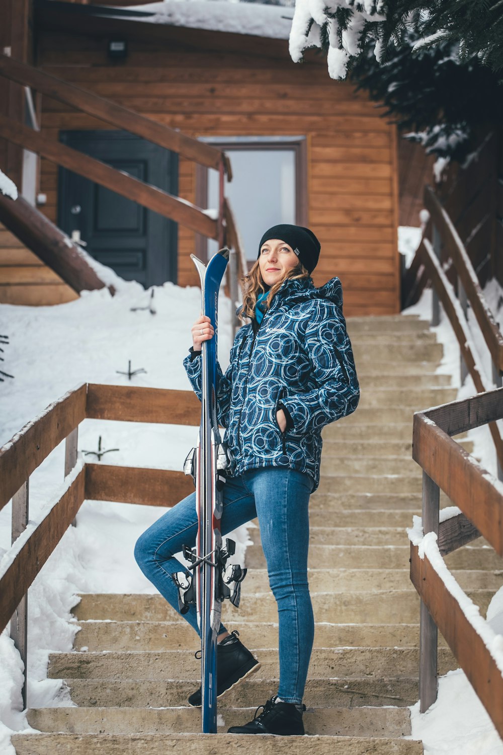woman standing on stairs holding skis