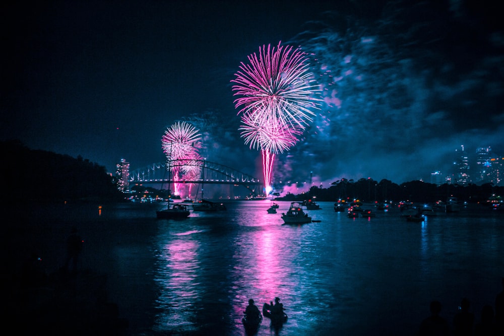fireworks above long bridge at night-time