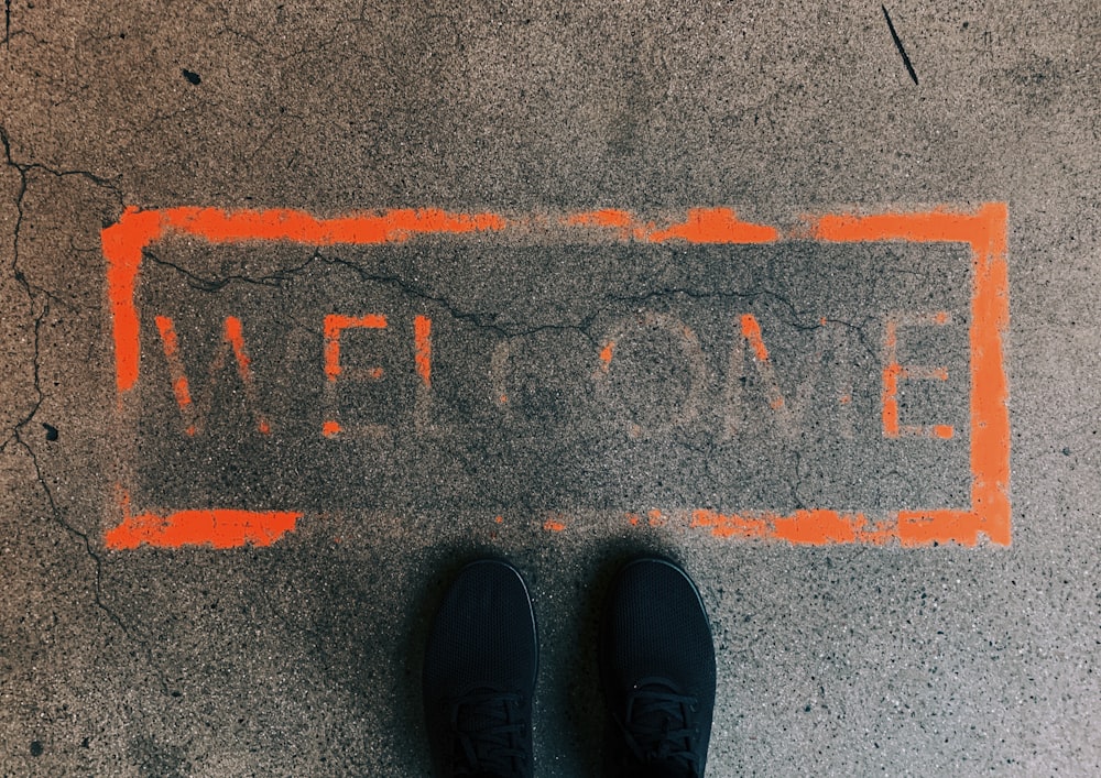 a person standing in front of a welcome sign