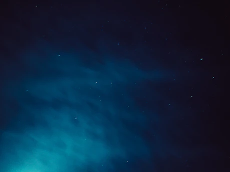 A delicate gold constellation map overlaying a deep indigo night sky.