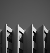 An aerial drone shot capturing a modern building with sharp lines and shadows.