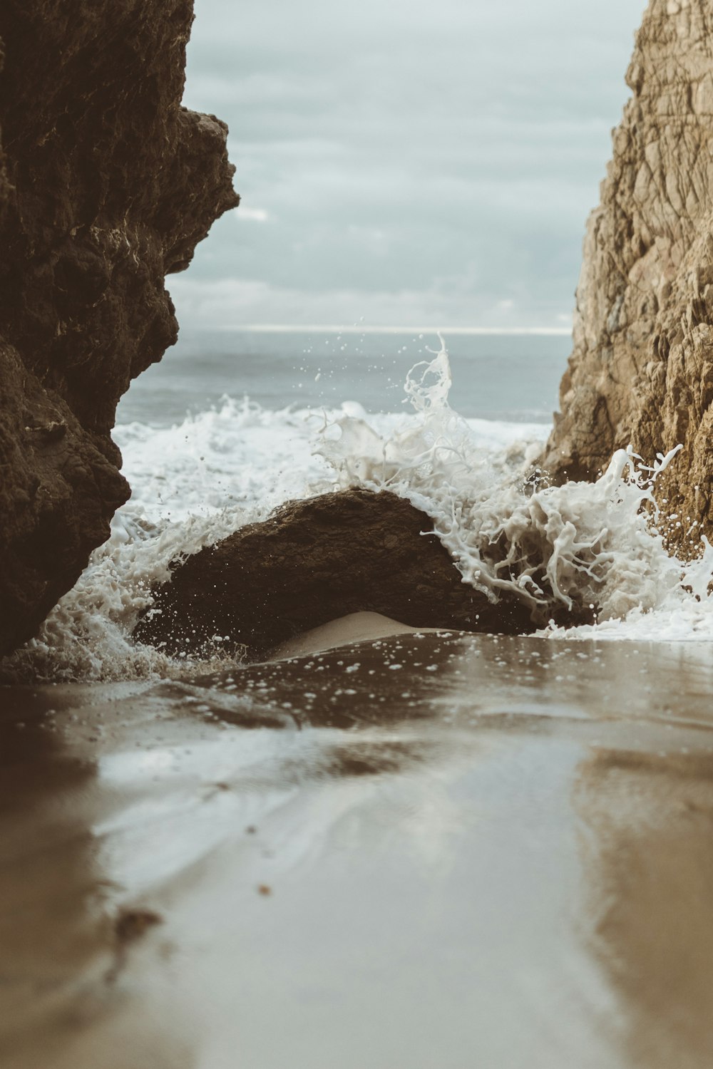 sea under rock formation during daytime