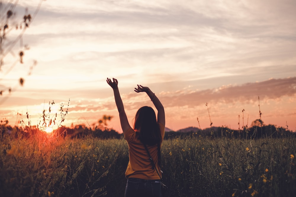 woman waving her hands during golden hour