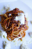 Close-up of a steaming plate of fresh tagliatelle with rich bolognese sauce.