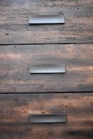 Close-up of elegant, handleless drawers in a high-end kitchen, showcasing fine wood grain and matte finishes.