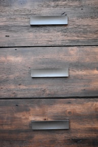 Close-up of hands fitting a wooden drawer, showcasing custom carpentry.