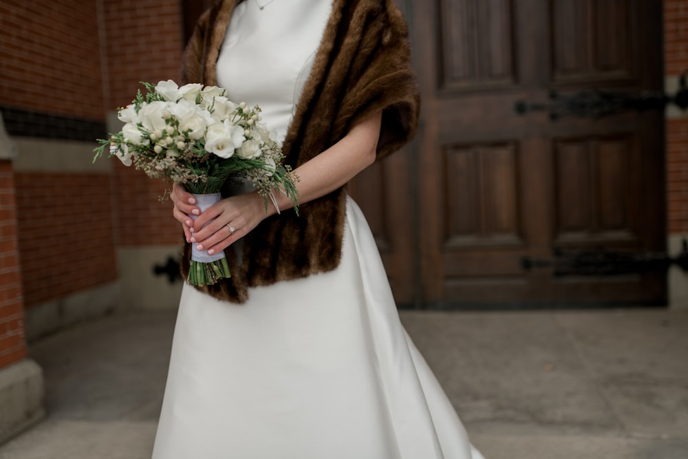 woman holding bouquet of white flowers