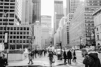A busy financial district with tall office buildings and professionals walking by.