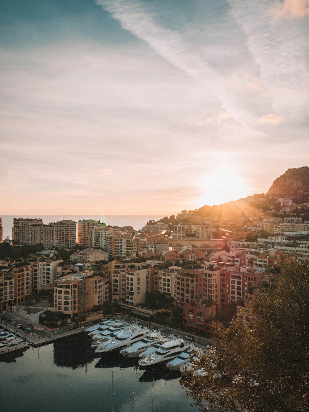 sun rising over hills near city by sea