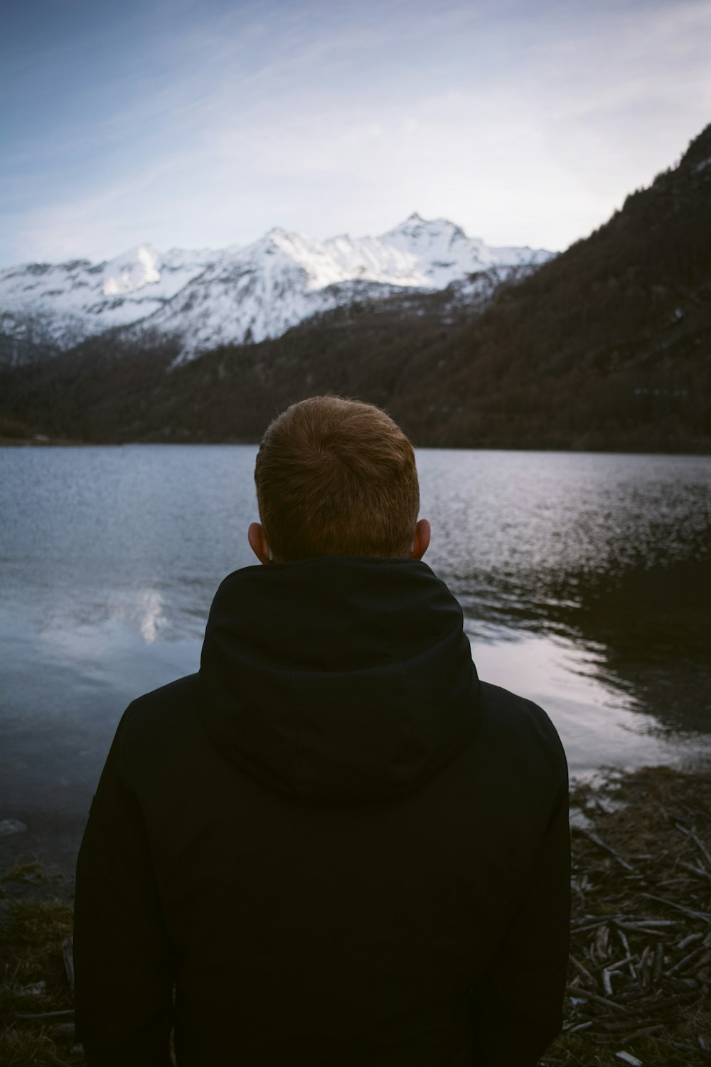 person wearing black jacket facing through body of water