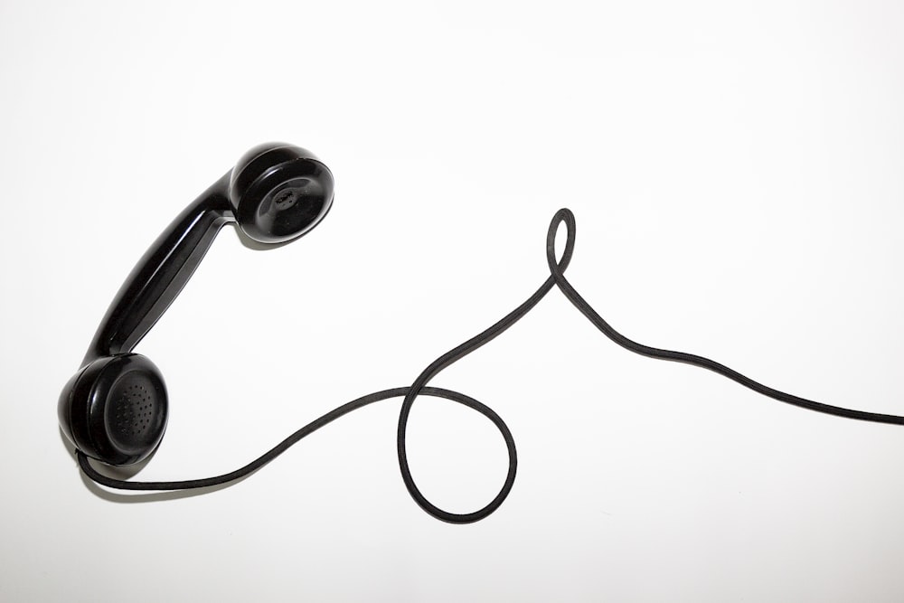 black corded telephone on white surface