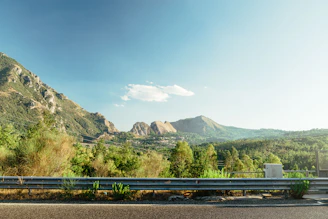 A sturdy yet stylish guardrail along a driveway with a scenic mountain backdrop
