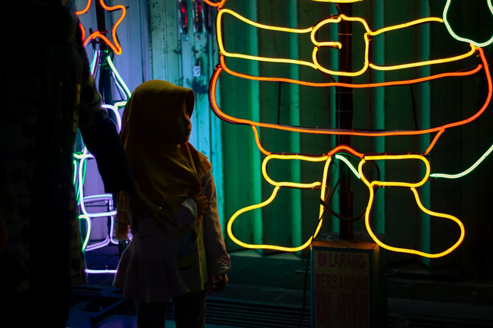 child standing in front of neon arts