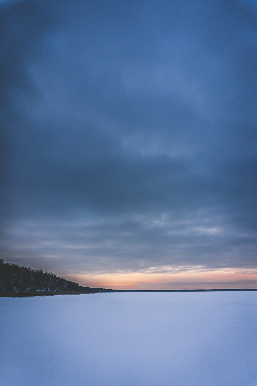 ice coated body of water under blue sky