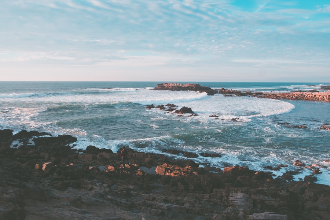 wavy ocean splashing on rock during daytime