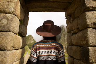woman standing under brown rock formation