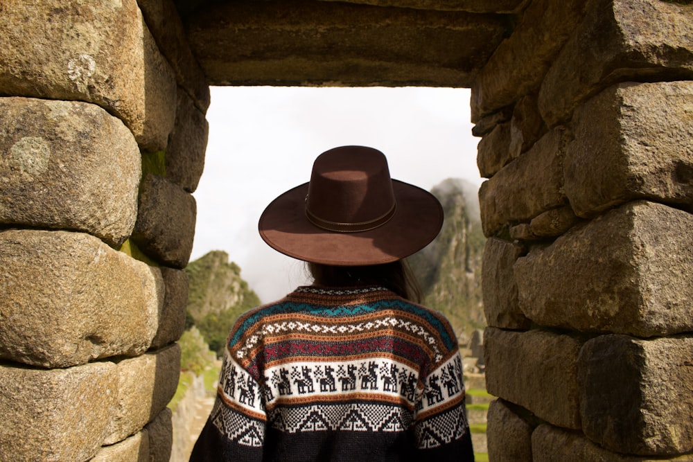 woman standing under brown rock formation