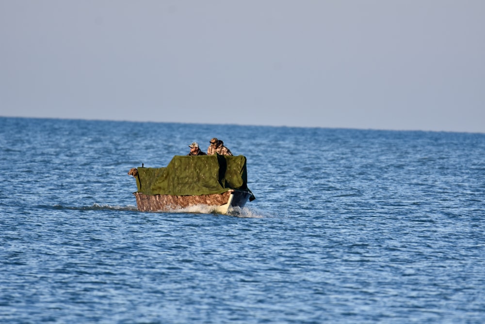 Grünes und braunes Boot tagsüber auf dem Gewässer