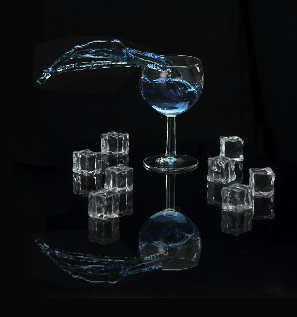 bicchiere da vino trasparente e otto cubetti di ghiaccio