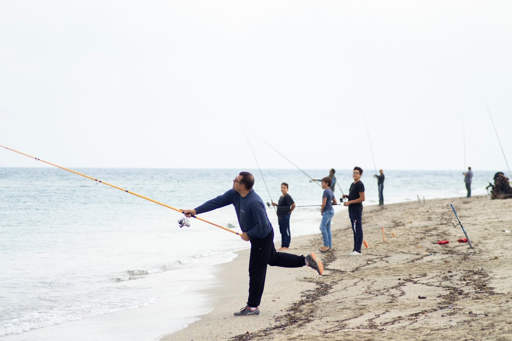 people fishing on seashore
