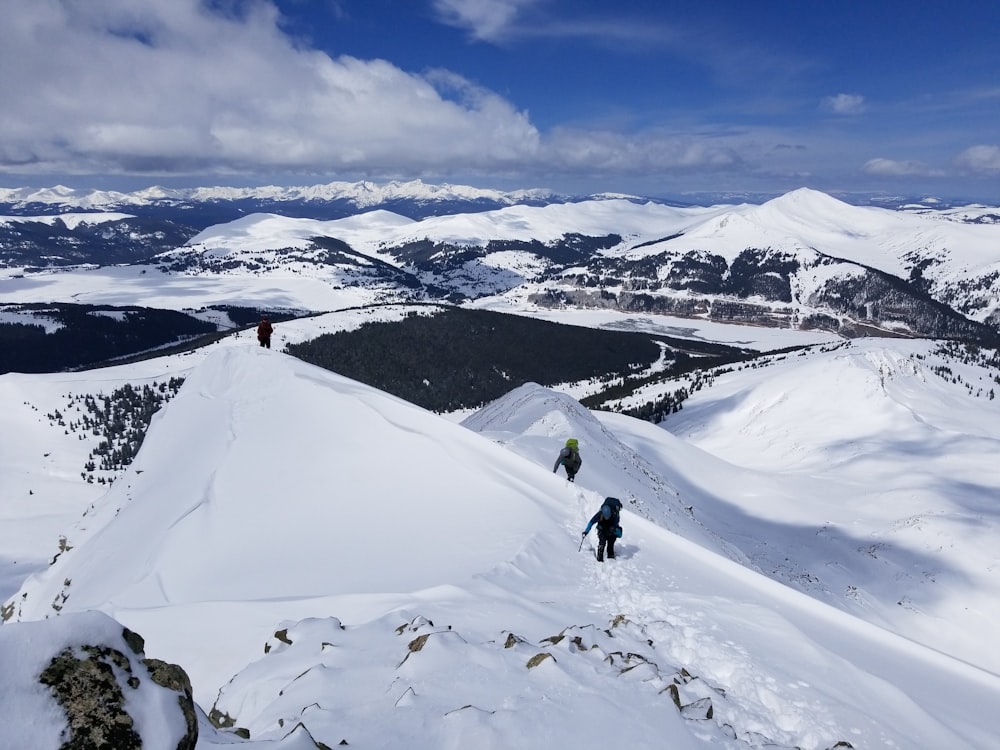 two people walking on snowy mountain during daytime