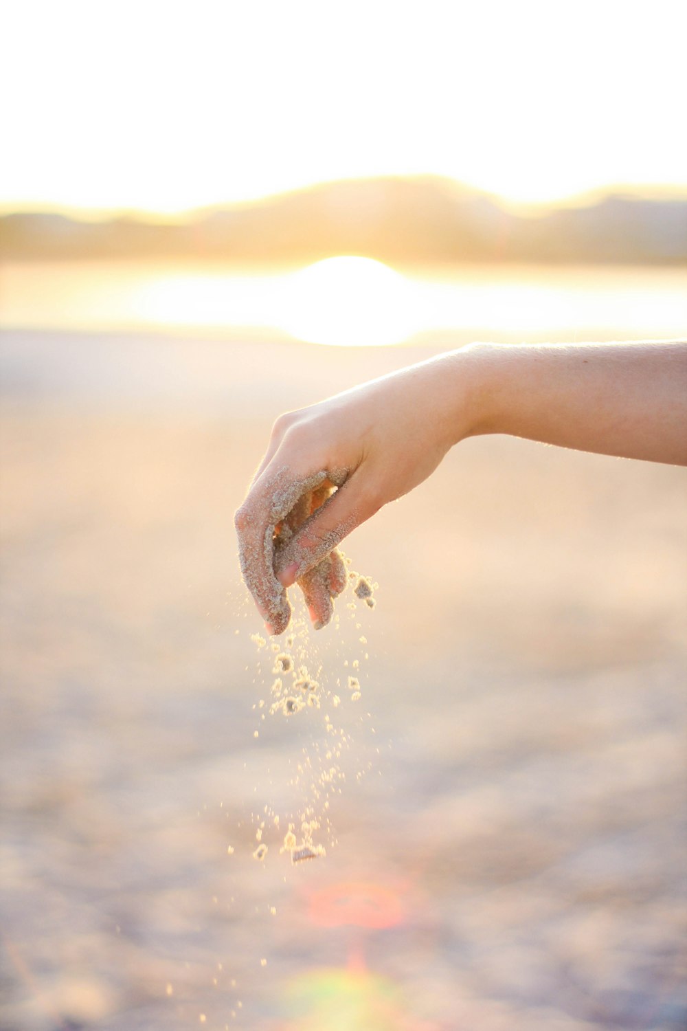 person dropping grains of sand