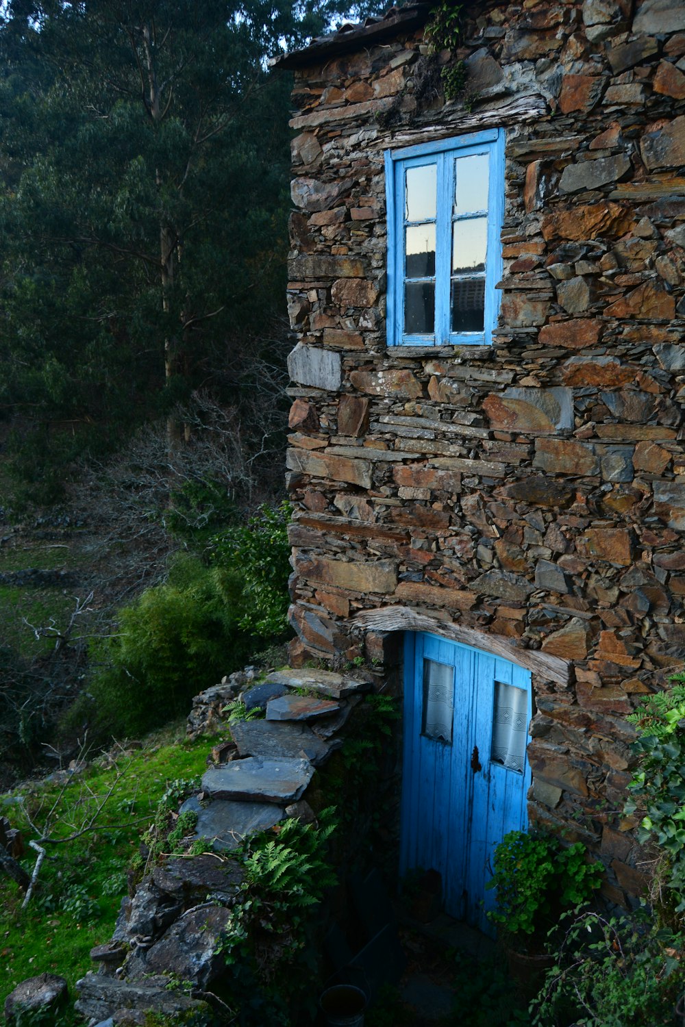 brown stone 2-storey house with blue door and window