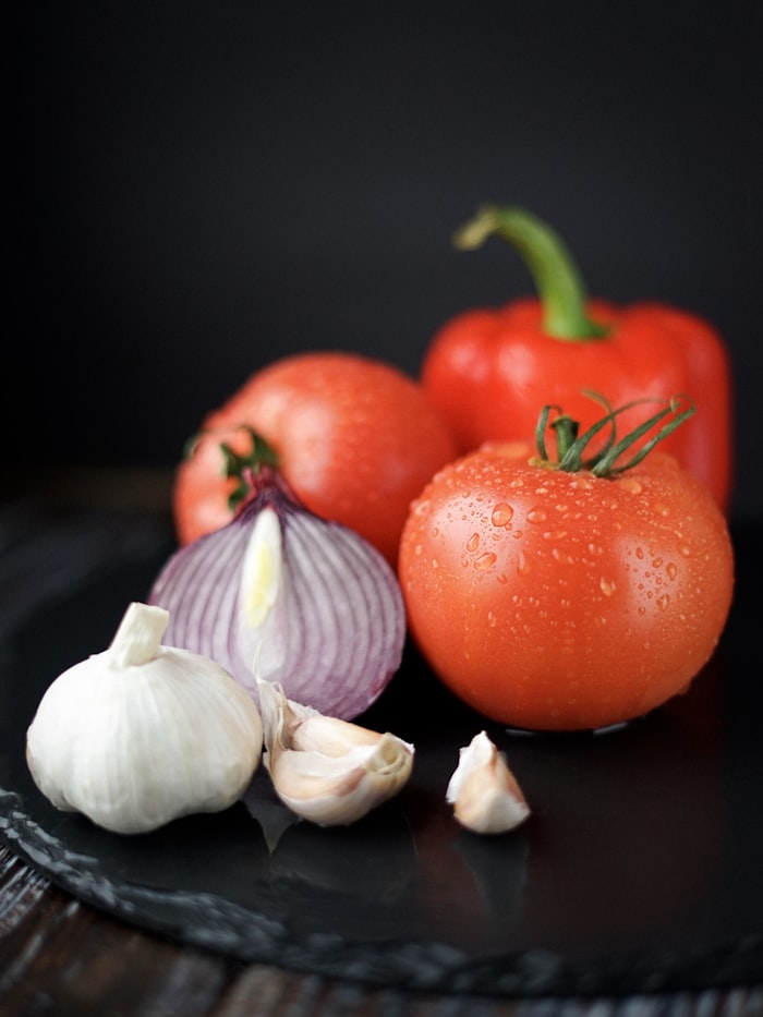 Ajo, cebolla y tomates frescos, alimentos prebióticos que nutren a las bacterias beneficiosas del intestino