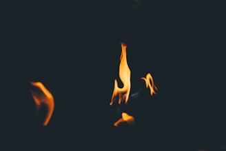 A dramatic dark background with glowing embers and flames, symbolizing spiritual purification.